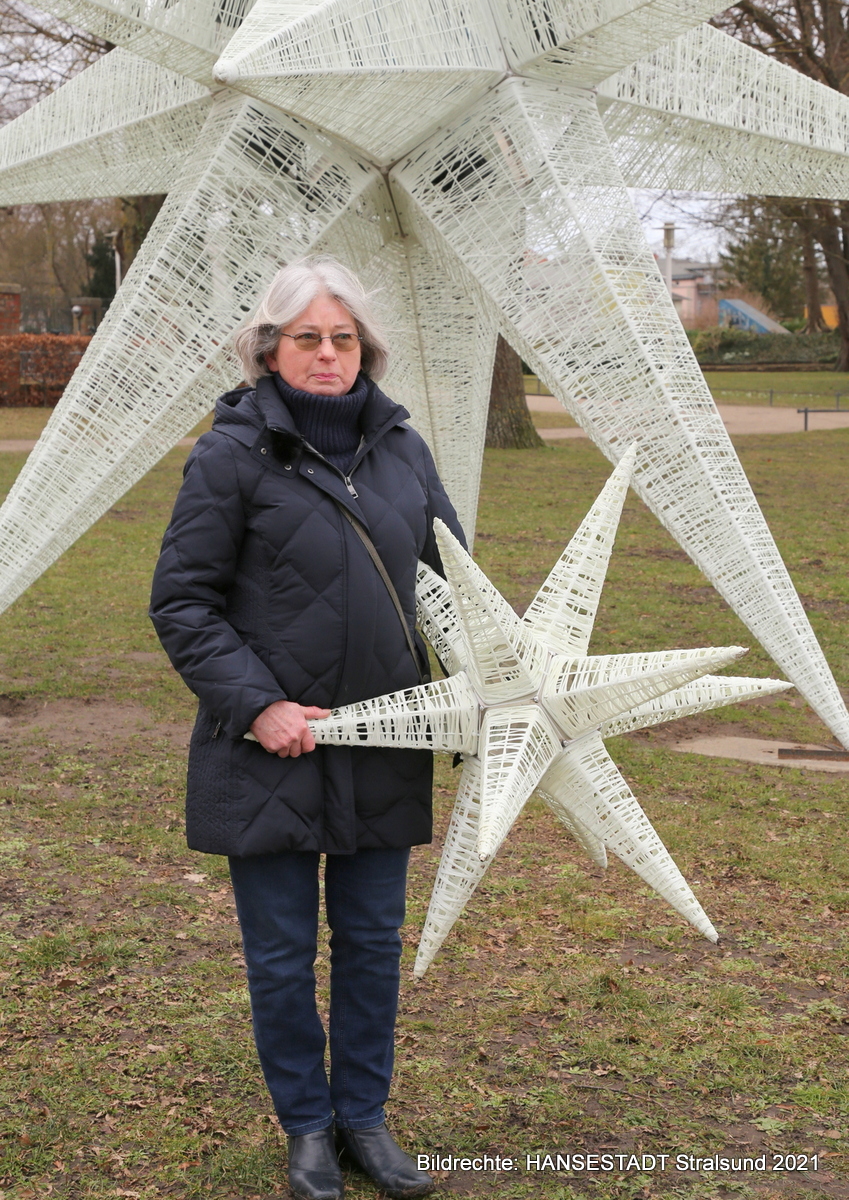 Die Gewinnerin des Fotowettbewerbes ‚Stralsund - Stadt der Sterne‘, Karin Lehm, mit ihrem kleinen vor dem großem Stern.