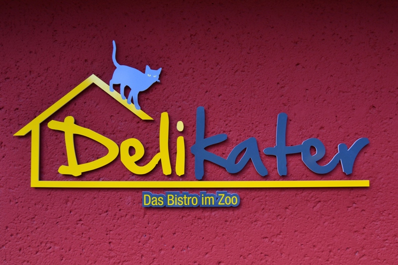 Das Logo des Zoobistros Delikater an der roten Wand des Gebäudes.